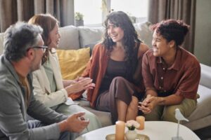 A group of four friends engaged in a deep conversation on a cozy sofa, surrounded by warm lighting and soft decor.